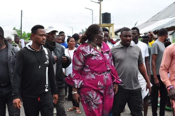 Tombra Mohammed walking through a community with supporters